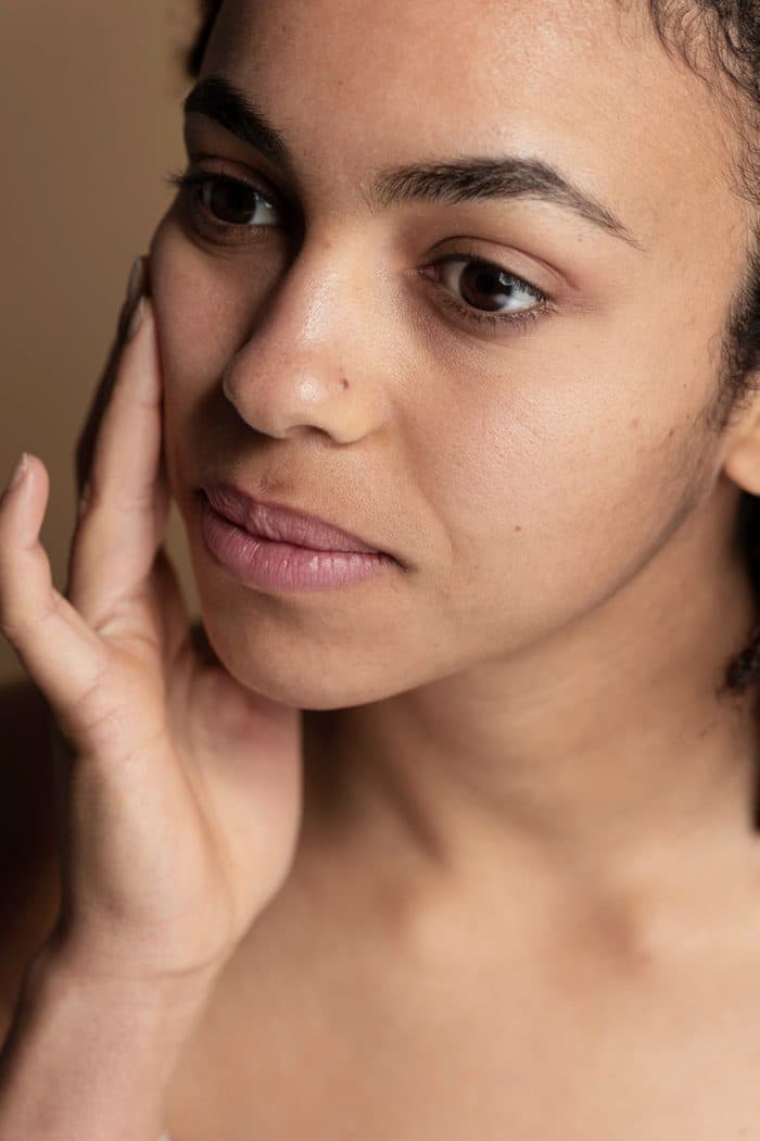 A member resting a hand against her jawline